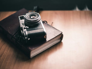Vintage camera resting on a leather journal, symbolizing the human perspective behind the CX Automation Revolution