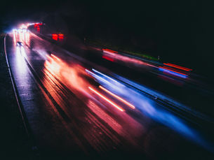 Long-exposure image of cars speeding down a highway at night, representing the shift from fast replies to meaningful Messaging KPIs in customer experience