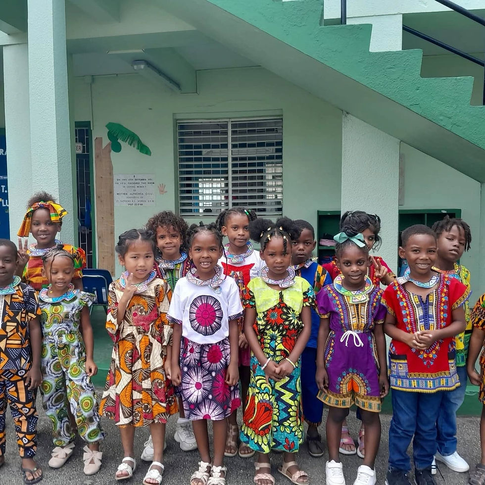 Children proudly display vibrant African attire during a cultural celebration at school, showcasing colorful patterns and traditional designs.