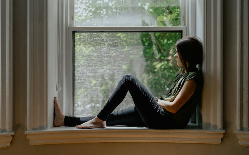 A woman sitting quietly at a window