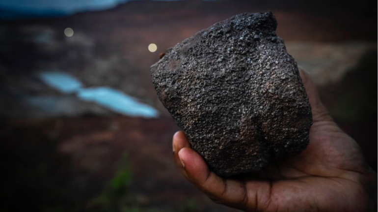 A mining engineer shows a piece of chromium ore at a mine near Kaliapani village in Jajpur district, Odisha | Moneycontrol