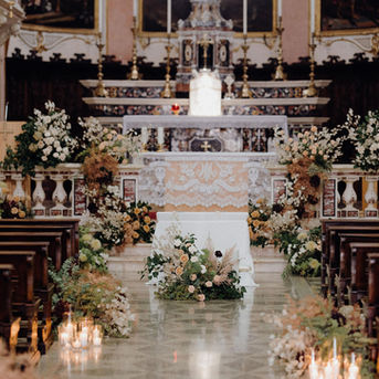 Ricco Allestimento floreale e candele su navata chiesa