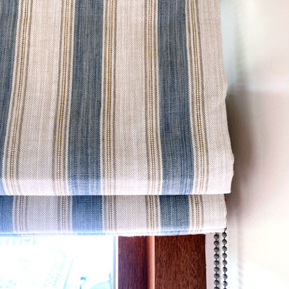 Image of striped fabric professionally made, hand-sewn roman blind with a side-winder chain mechanism. Motorised remote controlled blinds also available.
