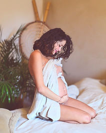 Femme enceinte sur lit, style bohème, ventre rond, cocooning