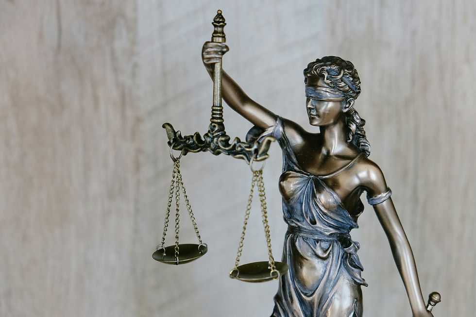 A photo of a bronze statue of Lady Justice holding her scales and sword.