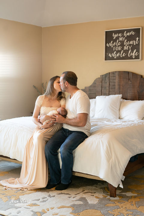 New mother and father holding newborn baby during lifestyle session in Dripping Springs home