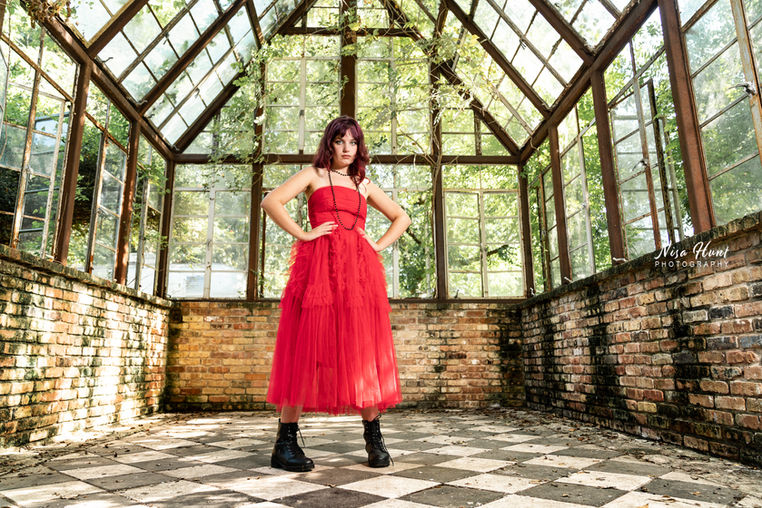 Senior girl in prom dress and boots during Austin session at Sekrit Theater greenhouse location