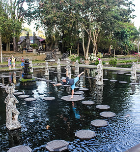 Someone doing yoga on a stone pathway in the pond 