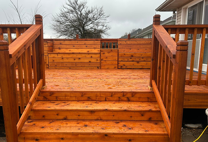 Newly stained red cedar deck with custom benches and planters