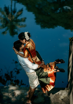 A cute picture of groom carrying his bride near backwater