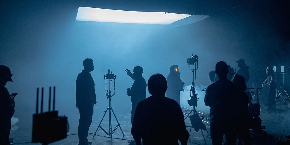 Wide shot of a film production team coordinating on set, illustrating collaboration and production leadership.
