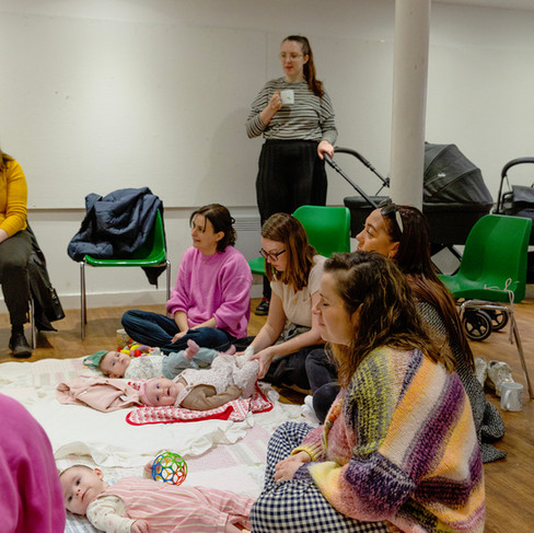 Mum and babies in the venue. Listening to the specialist. Babies are playing on the floor