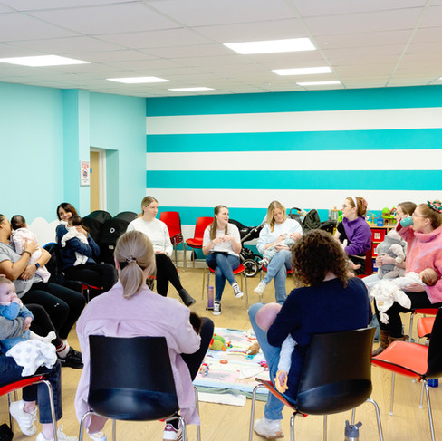 Mums sitting in a circle on chairs listening to our specialist.