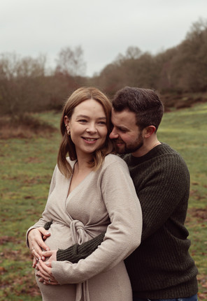 Newborn Photographer Hertfordshire - Evie Grace Photography.  A pregnant couple with a dog hugging together on a maternity photo shoot