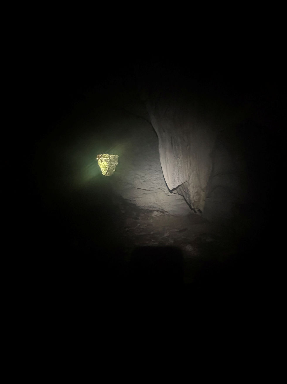 dunkle Höhle, Ausgang in der Ferne ersichtlich, durch den Licht in die Höhle fällt.