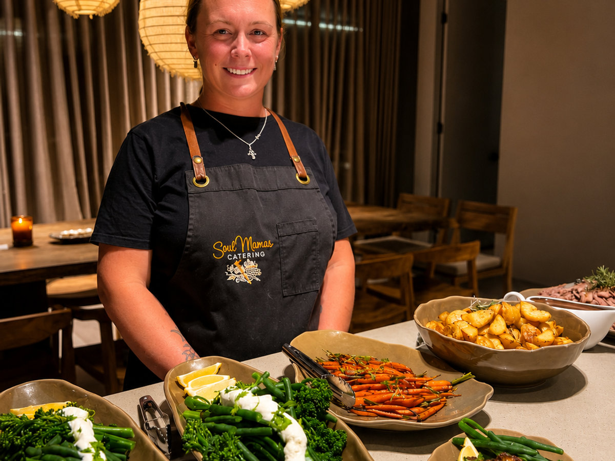 Jessmyn Toovey in a Soul Mamas apron behind a table of roast vegetables