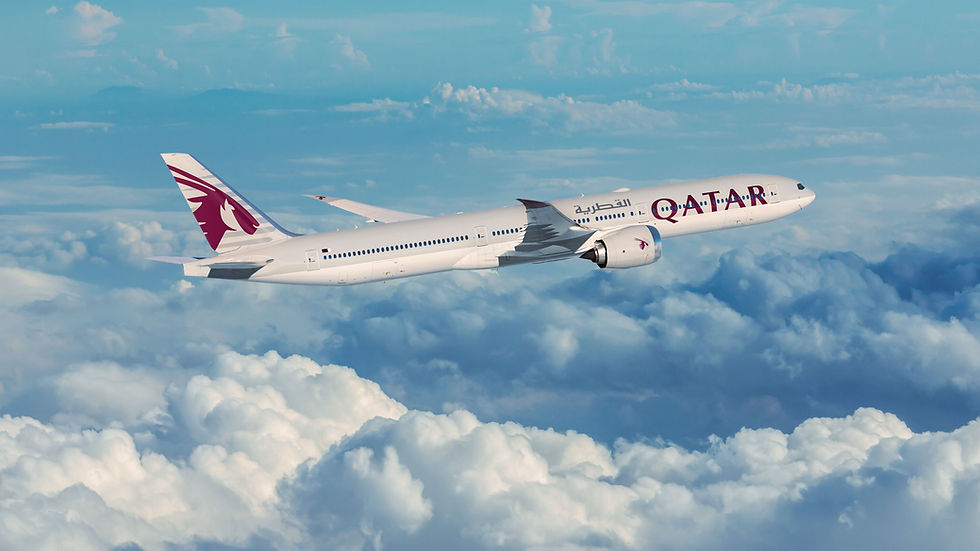 A Qatar Airways plane soars gracefully above a blanket of clouds, showcasing the airline's sleek design and its commitment to excellence in air travel.