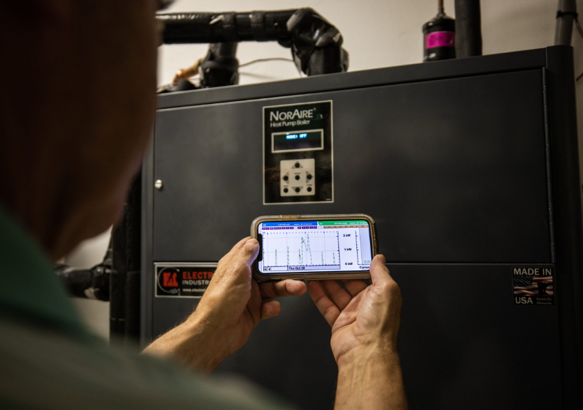 A person servicing a heat pump.