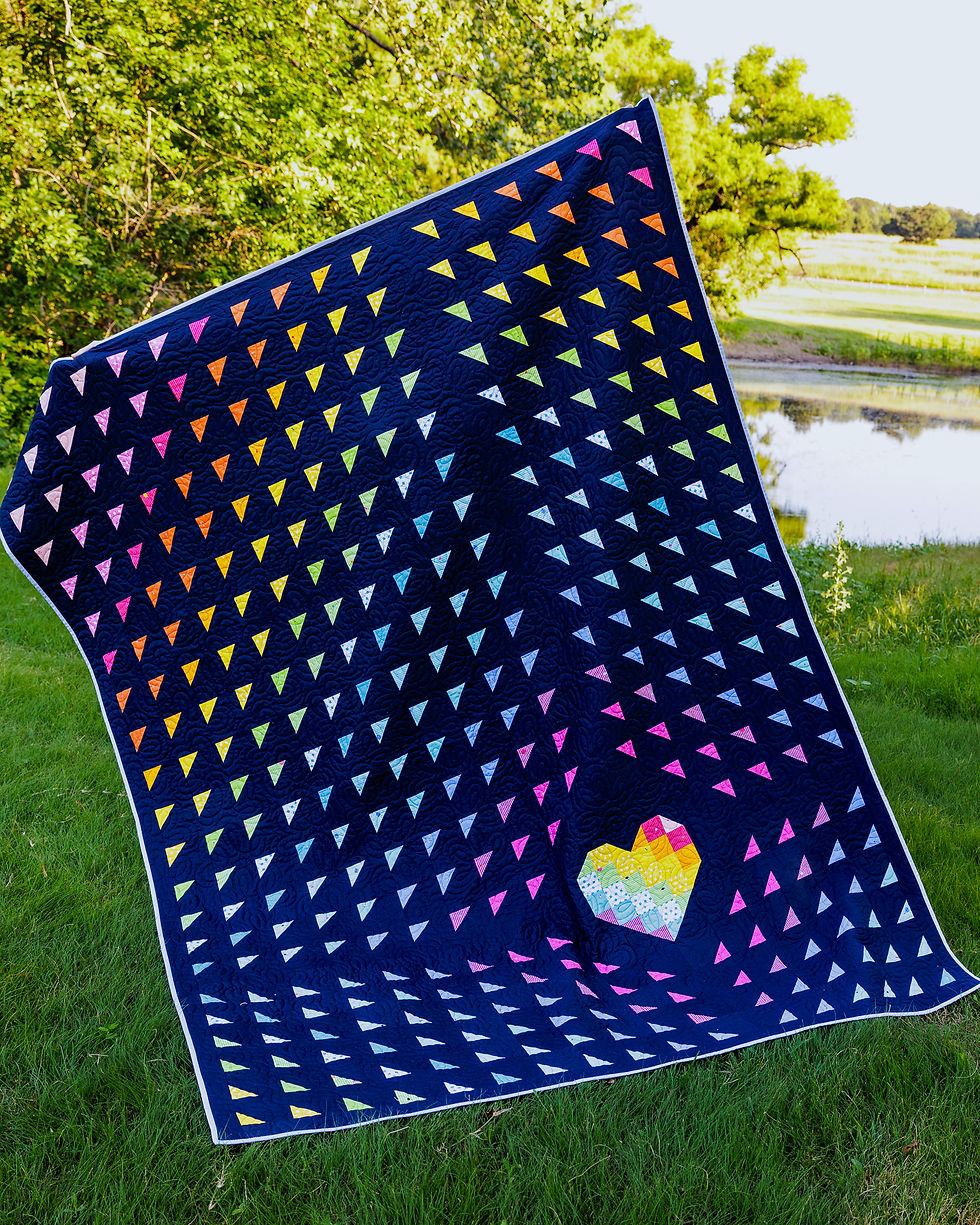 Dark blue quilt with colorful triangles and a heart