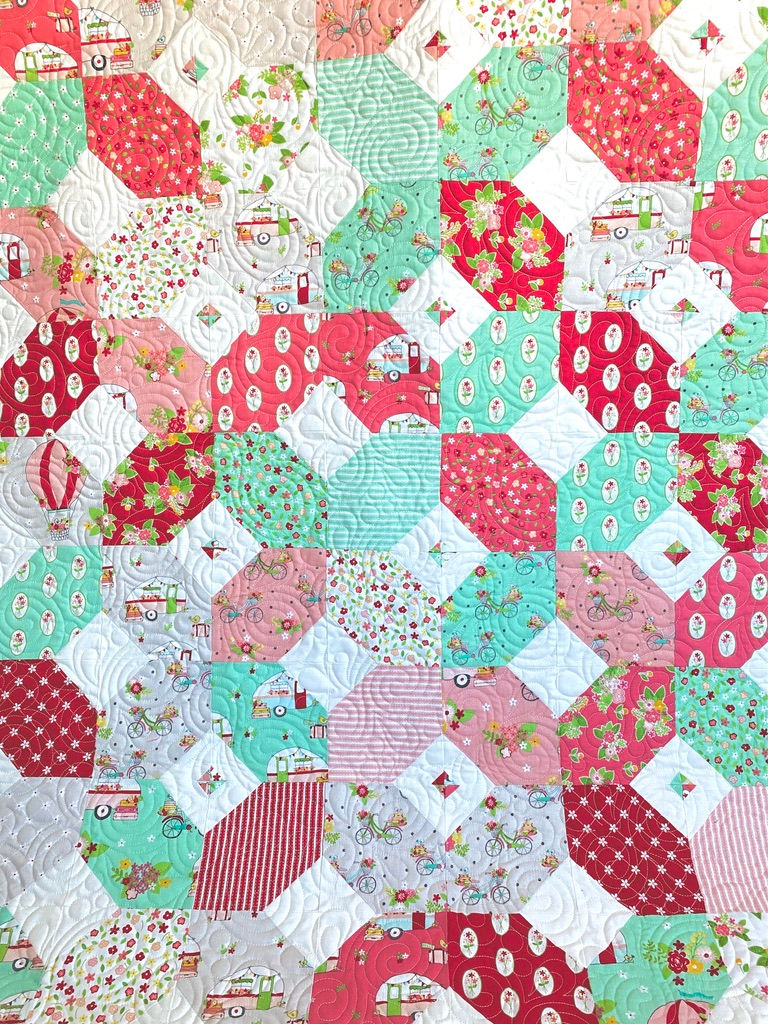 Thumbnail: Patchwork quilt with red, pink, and mint green geometric patterns