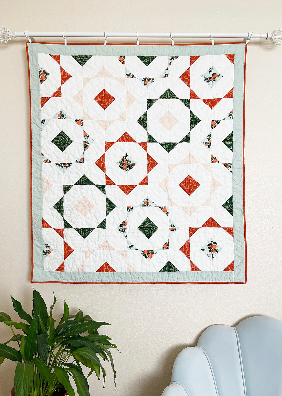 Thumbnail: White quilt with red and green geometric and floral patterns