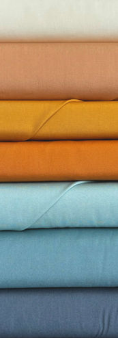 Stacked fabric rolls in various muted colors