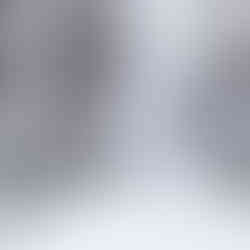 Ramp with railings covered in snow and ice during a snowstorm. Three people, trees, and buildings.