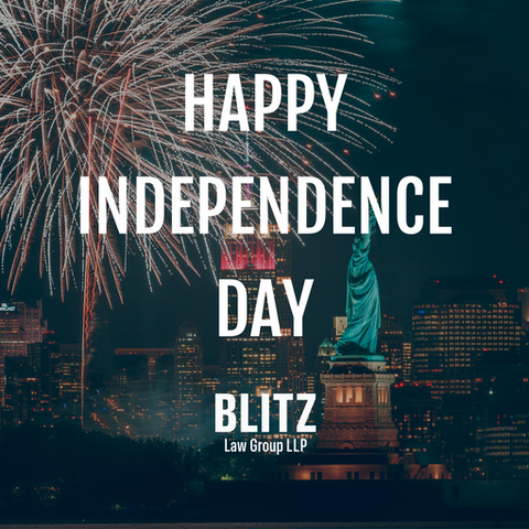 Fireworks light up the night sky behind a city skyline and the Statue of Liberty. Text reads: "Happy Independence Day Blitz Law Group LLP." Photo by USATILITY.