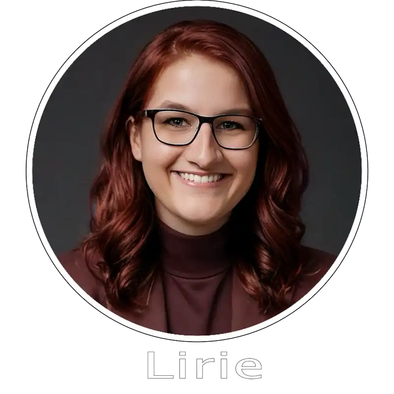 Lirie in Brille lächelt in die Kamera. Portrait mit rotem Haar.