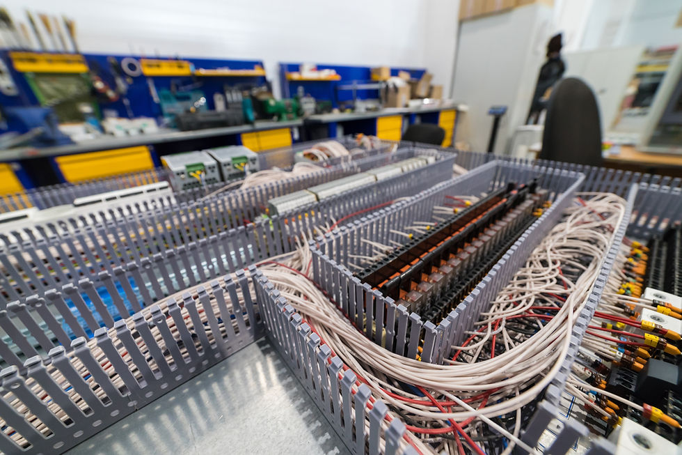 Electrical cabinet containing relays and wires connecting to a control panel.jpg