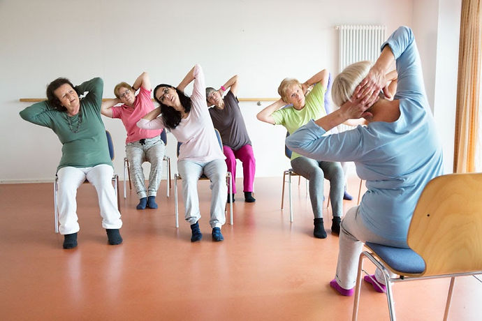 Class of older women enjoying chair yoga
