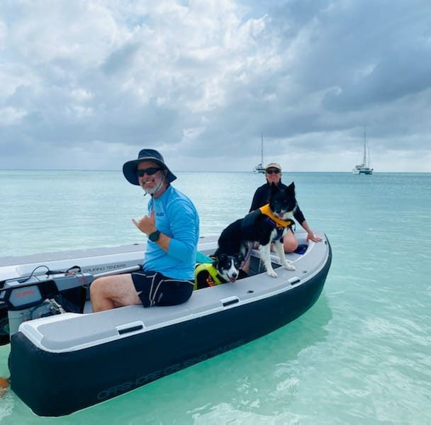 A couple and a dog on a small boat