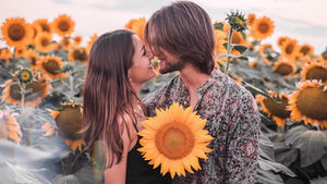 A couple in Tulsa, OK, walking through a sunflower field, exploring the purpose of dating.