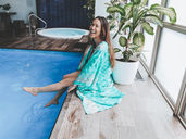a woman sits on the edge of a spa pool