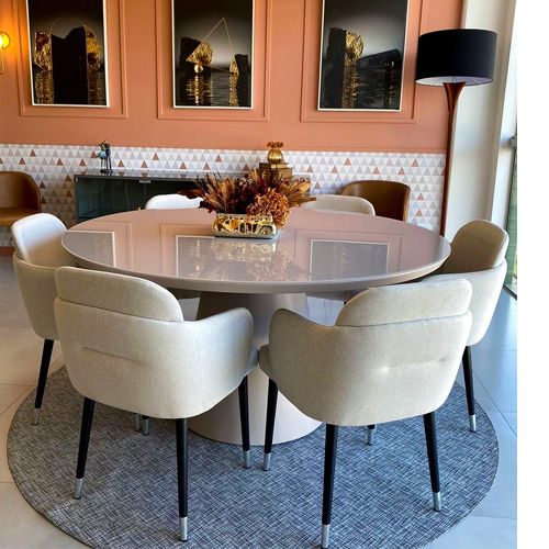 Miniatura: Mesa de jantar redonda, cadeiras estofadas claras em sala de jantar moderna.
