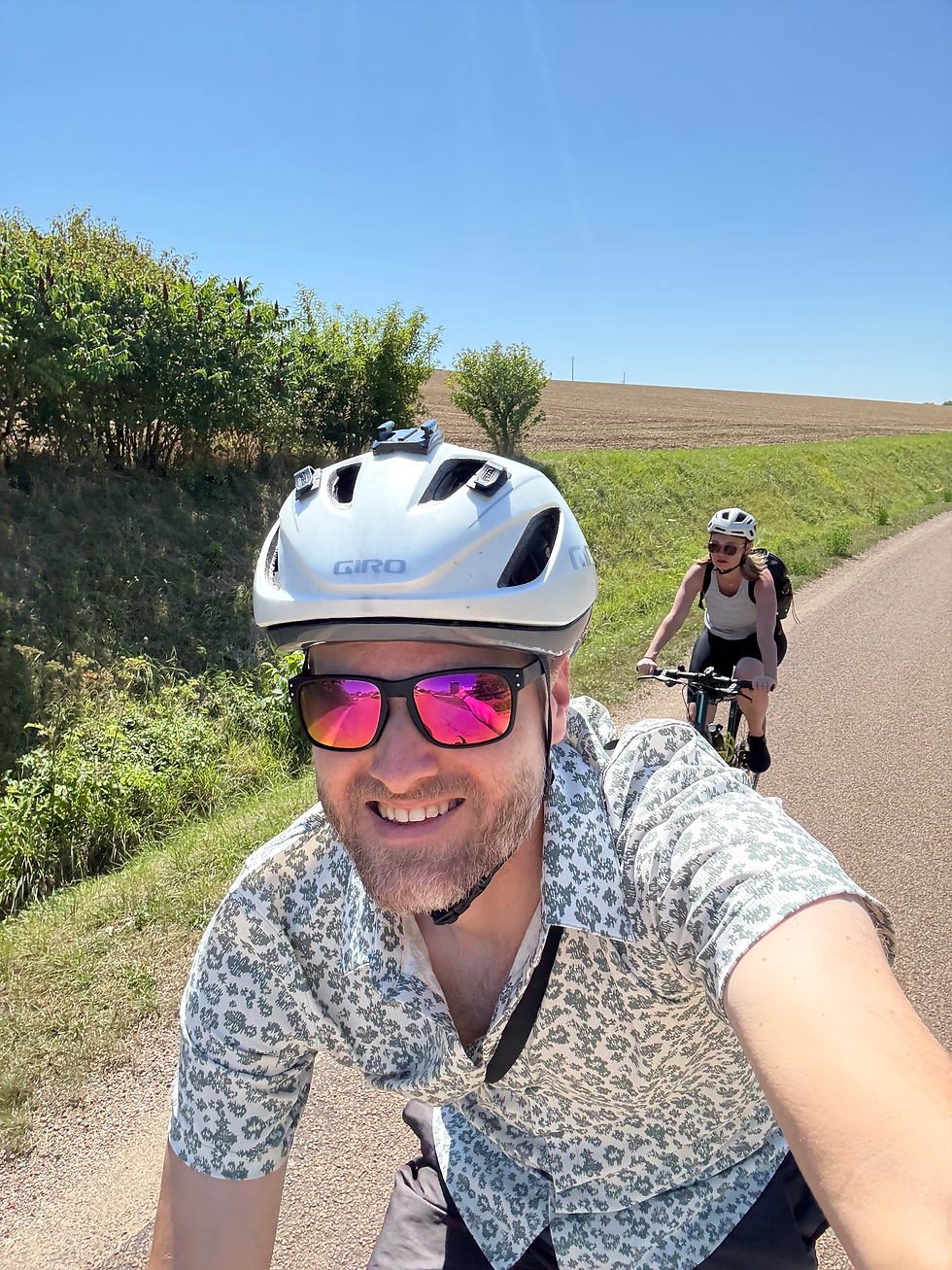 2 cyclists riding through the vineyards and farmland surrounding Chablis