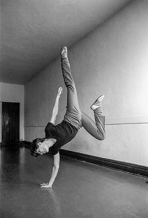 black and white photo of caucasian man doing a hand stand