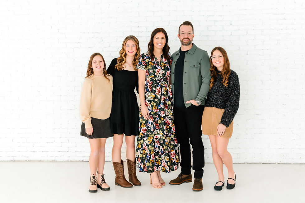 family posed standing together at a studio for a family photo