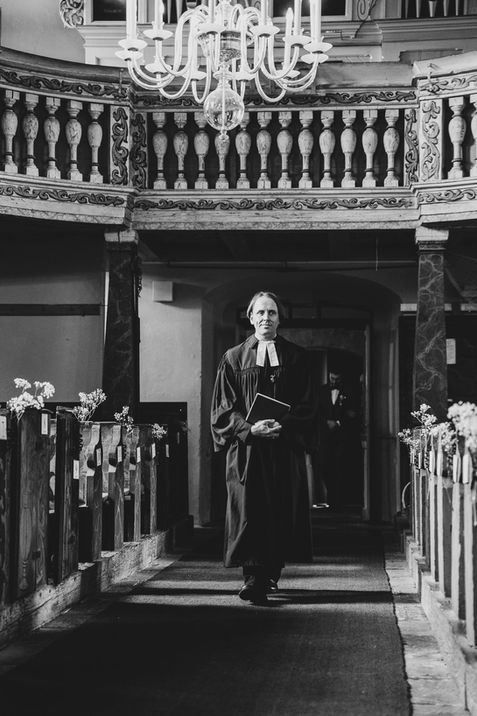 Pfarrer kommt in die Kirche