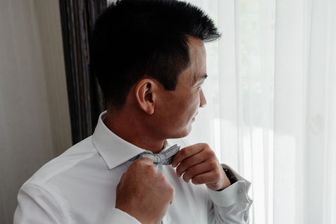 Bräutigam fasst sich an die Fliege