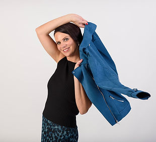 Frau schmeisst ihre blaue Lederjacke über die Schultern