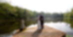 Bride and groom pose on dock overlooking a lake. Childers Photography watermark.