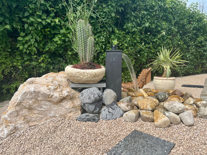 Une cascade d'eau au coeur d'un aménagement paysagé réalisé par La Batisse à Rahon 39120