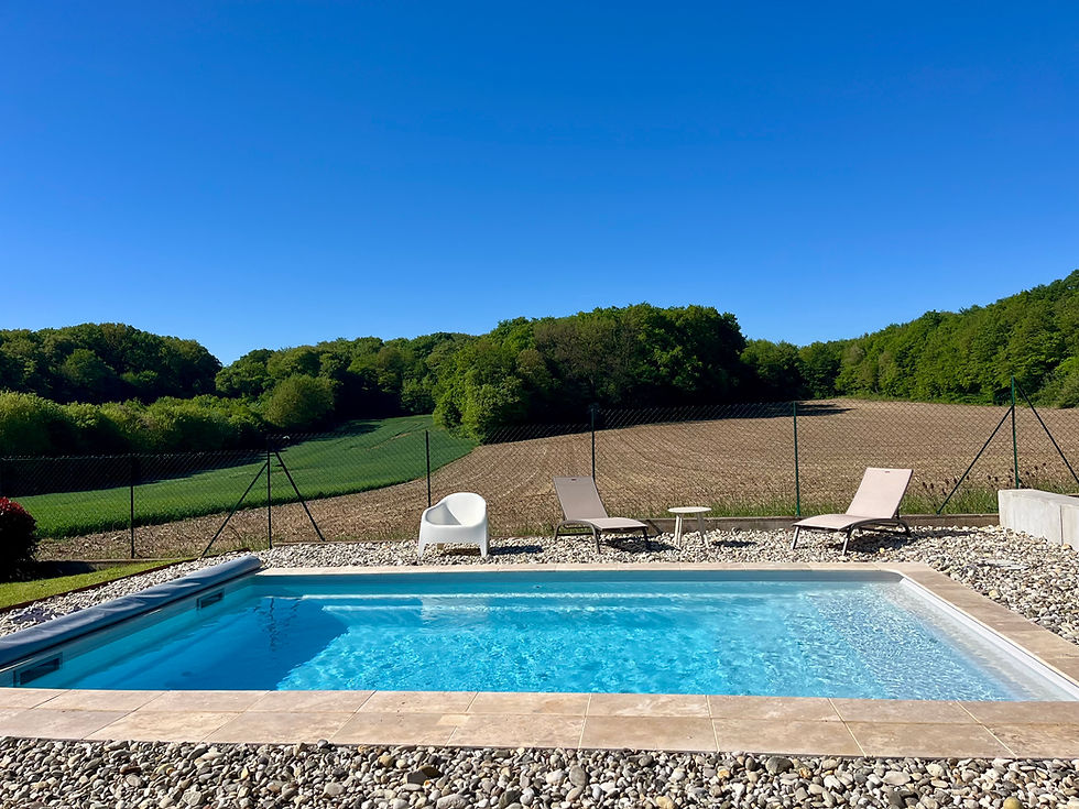 Piscine Widegrise avec margelles en travertin et galets en périphérie