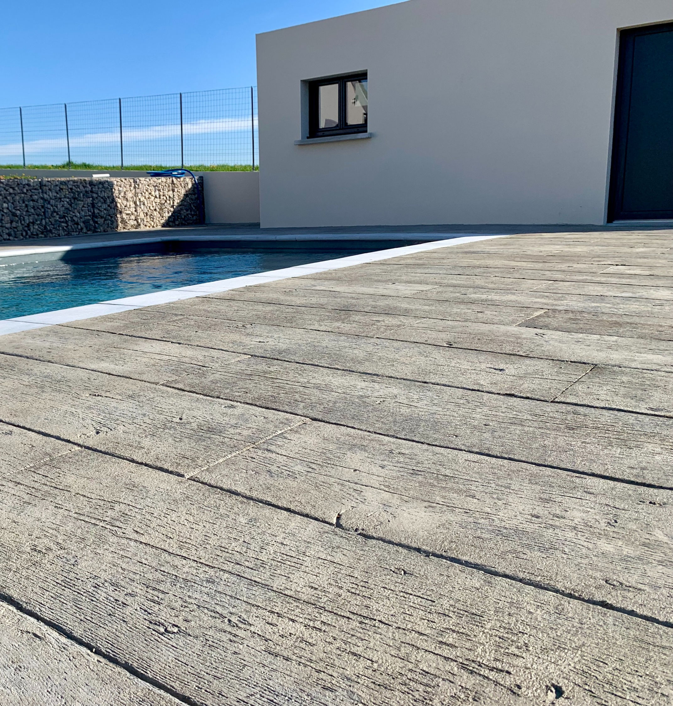 Béton Décoratif finition bois vintage autour d'une piscine