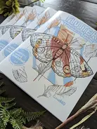 A coloring book featuring a large butterfly is called "Era" and is surrounded by decorative plants.