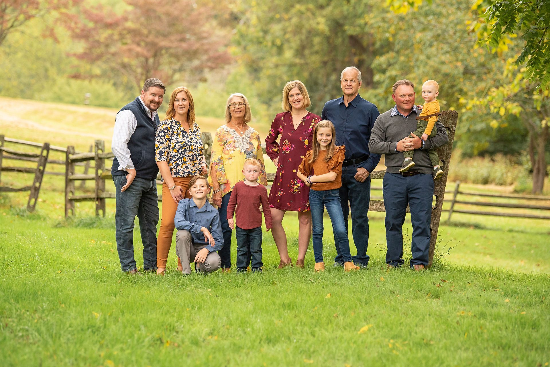 large family fall picture with wooden fence