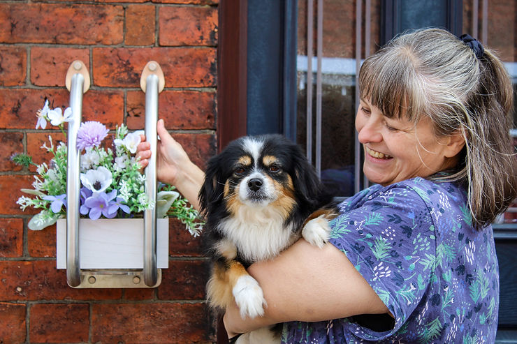 Lady holding a dog with the Plant Pot holder grab rail