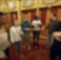 Felicia Curry, a short African American woman and Jim Stanek a white man stand on either side of 3 blind students who are attending a performance of the Into the Woods National Tour. They are being guided on a Touch Tour ahead of the performance curated by Felicia, Jim and Shane Dittmar.