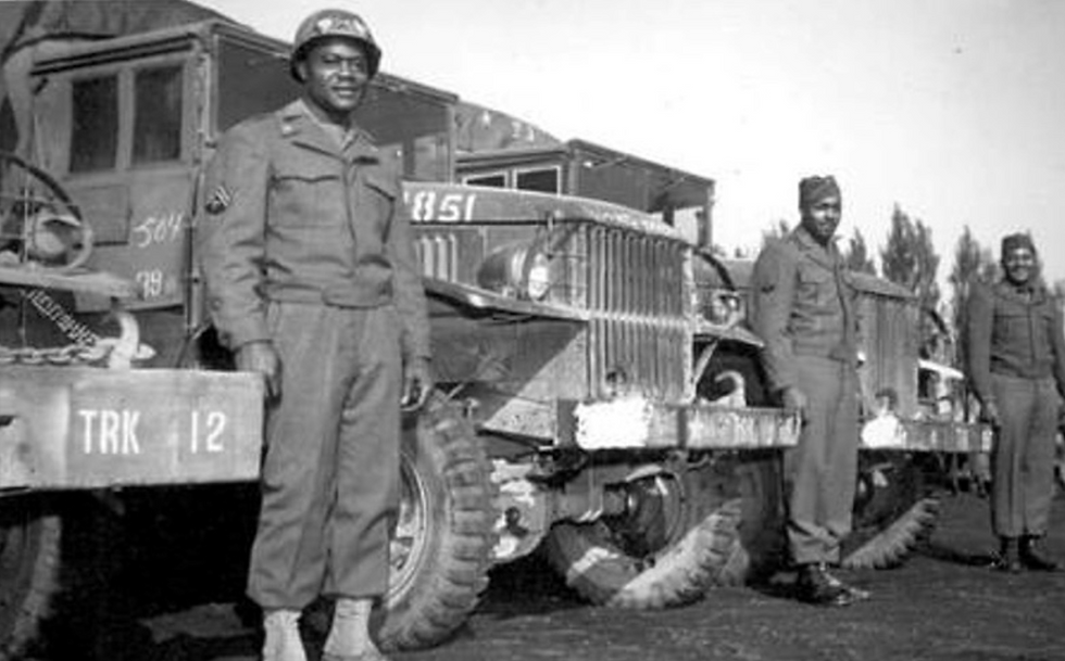 African American soldiers standing by Red Ball Express trucks